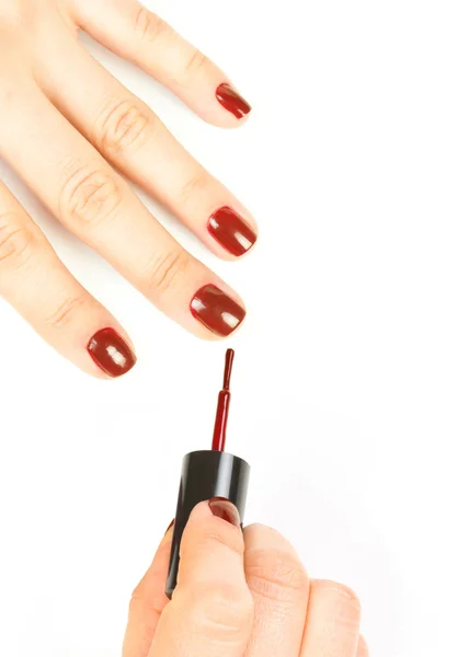 Manikiurzystka stosowania czerwony lakier do paznokci na kobiece palce. — Zdjęcie stockowe