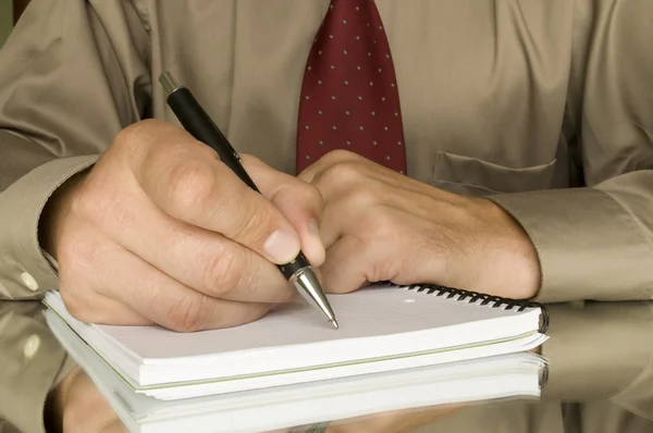 Pen in de hand schrijven op de notebook en reflectie — Stockfoto