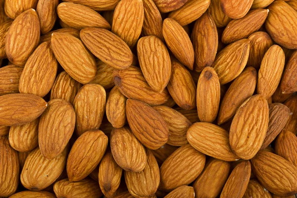 Heap of raw almonds nuts background — Stock Photo, Image