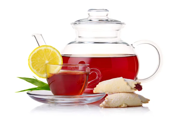Teapot and cup of black tea with crescent and lemon slice isolat — Stock Photo, Image