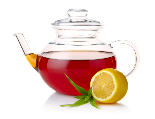 黒茶、緑の葉とレモンのスライス上に分離されてとティーポット — ストック写真