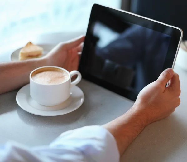 Człowiek posiadający komputera typu tablet w kawiarni — Zdjęcie stockowe