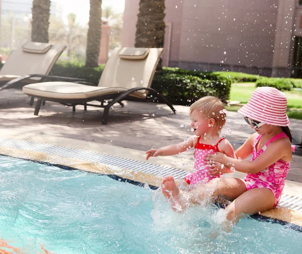 Twee kleine zusters spelen in zwembad — Stockfoto