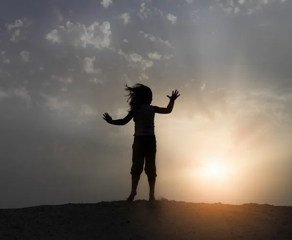 Маленькая счастливая девочка прыгает по пляжу — стоковое фото
