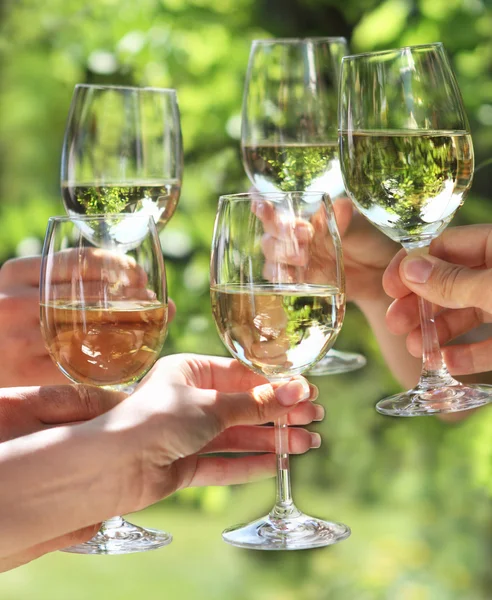 Segurando copos de vinho branco fazendo um brinde — Fotografia de Stock