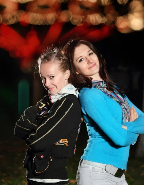 Молодые улыбающиеся девушки в ночном парке — стоковое фото