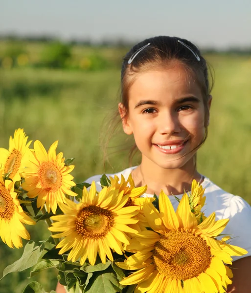 Schattige lachende kindje met zonnebloemen — Stockfoto