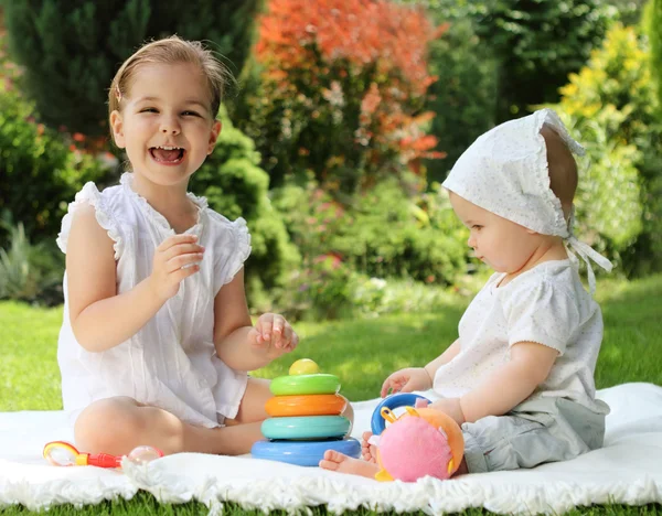 Two little sisters in the summer garden — Stock Photo, Image