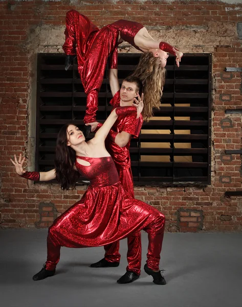 Dançarinos em ação contra a parede de tijolo — Fotografia de Stock