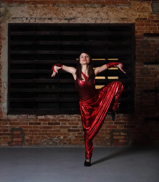 Mladá bruneta žena v červené tanec — Stock fotografie