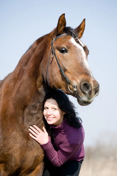 Junges Mädchen und braunes Pferd im Feld. — Stockfoto