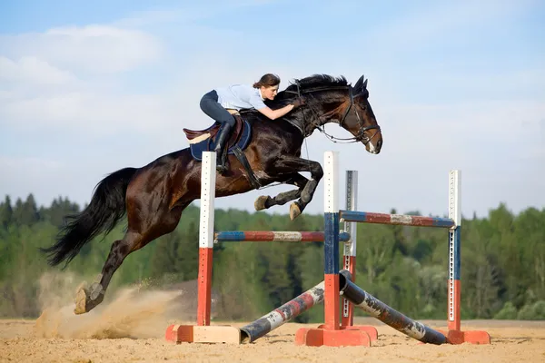 Junges Mädchen springt mit braunem Pferd — Stockfoto