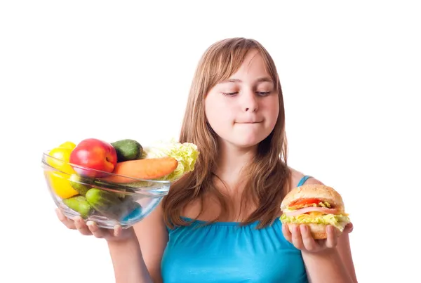 Menina com legumes e hambúrguer — Fotografia de Stock