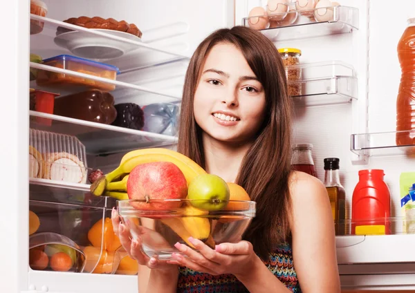 Leende flicka med frukter på köket — Stockfoto