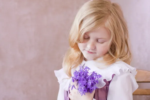 Porträt eines kleinen hübschen Mädchens mit Blumen — Stockfoto