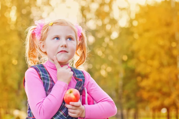 Школярка з яблуком на відкритому повітрі — стокове фото