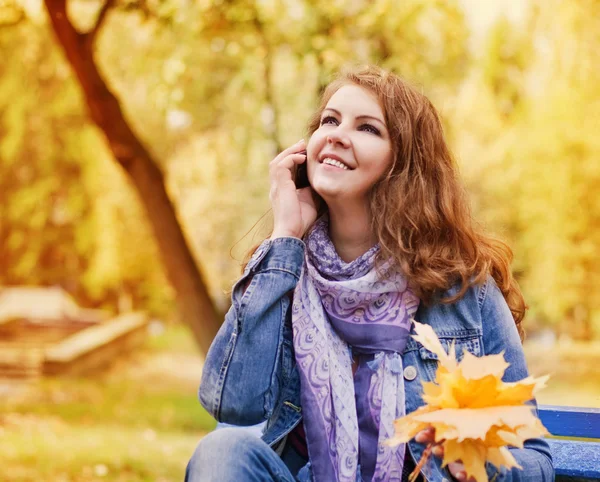 Счастливые женщины с телефоном в осеннем парке — стоковое фото