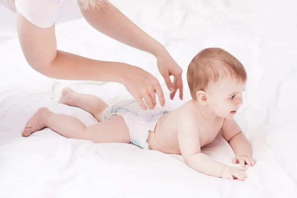 Mãe massagear e exercitar seu bebê pequeno — Fotografia de Stock