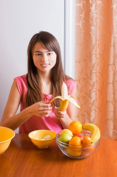 Vacker flicka med frukter på kök — Stockfoto