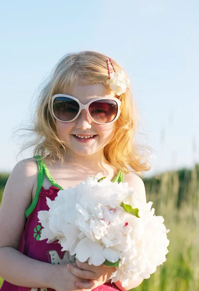 Kleines Mädchen mit Blumen — Stockfoto