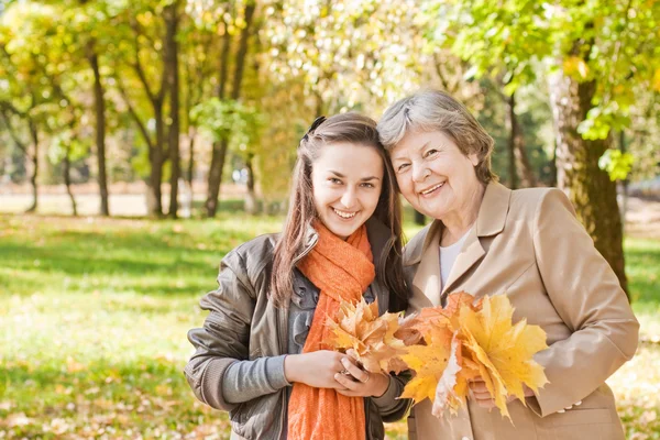 Chica con la abuela en el parque de otoño — Foto de Stock