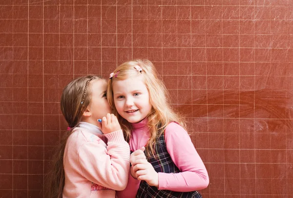Schulmädchen erzählt einer geheimen Freundin — Stockfoto