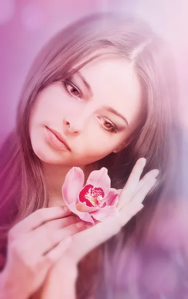 Vacker flicka med orkidé blomma — Stockfoto