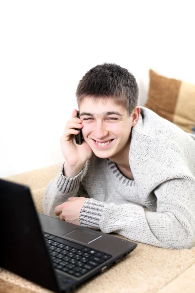 Подросток с ноутбуком и телефоном — стоковое фото