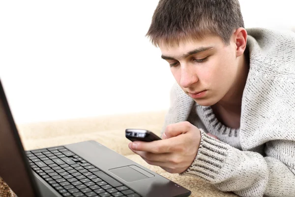 Підліток з ноутбуком і телефоном — стокове фото