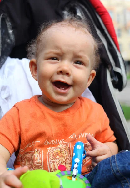 Menino feliz com carruagem de bebê em — Fotografia de Stock