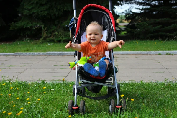 Little happy boy with baby carriage in — Stock Photo, Image