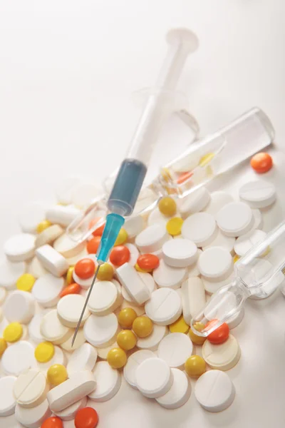 Syringe and pills on a white background — Stock Photo, Image