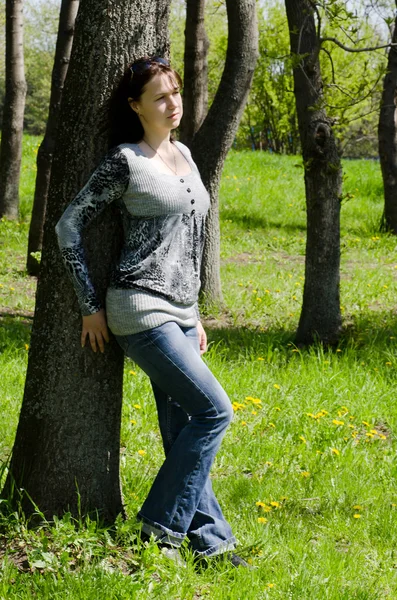 The beautiful girl at a tree in the summer — Stock Photo, Image