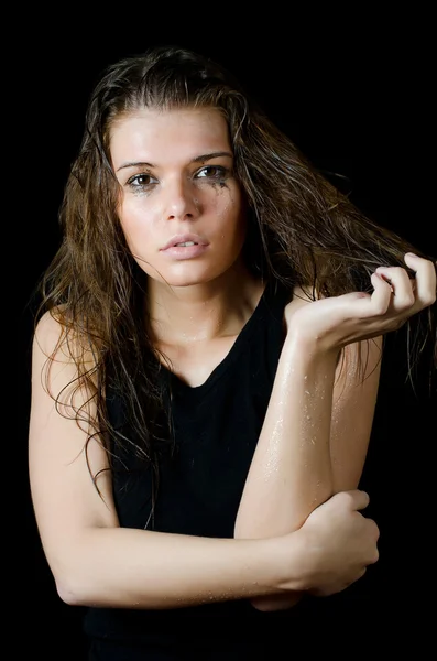 Das nasse Mädchen mit der aufgestrichenen Kosmetik auf dem schwarzen — Stockfoto