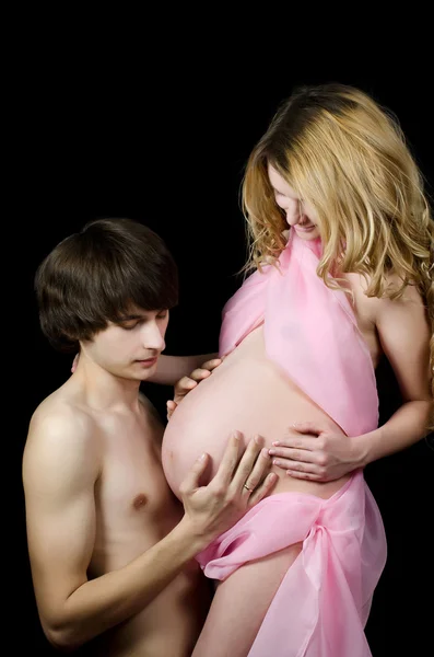 Lyckliga gravida par på svart — Stockfoto