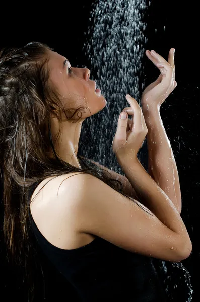 A menina abaixo de um chuveiro no preto — Fotografia de Stock