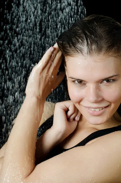 La muchacha bajo la ducha sobre negro — Foto de Stock