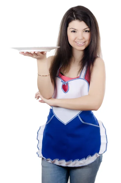 Девушка в фартуке держит тарелку — стоковое фото