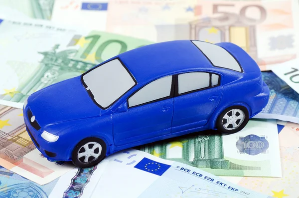 Das Spielzeugauto für Euro-Banknoten als Hintergrund — Stockfoto