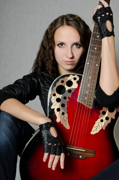 Das schöne Mädchen in Lederjacke mit Gitarre — Stockfoto