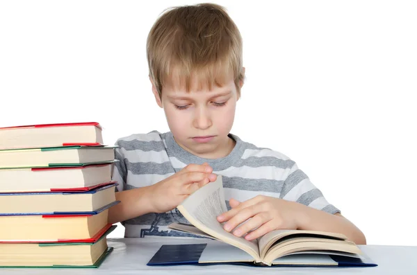 Poika lukee kirjaa, joka on eristetty valkoisesta. — kuvapankkivalokuva