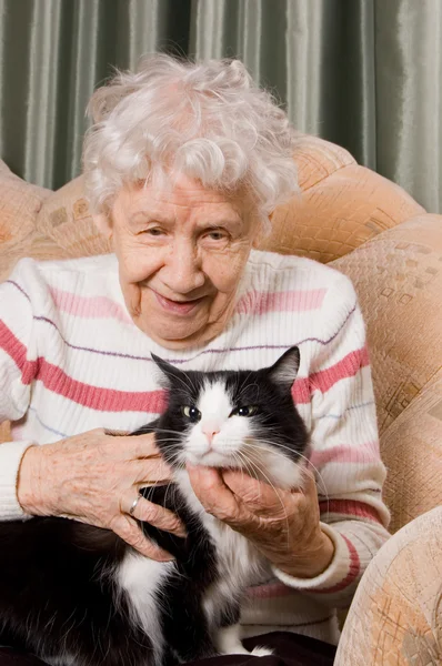 Die Großmutter mit der Katze auf dem Sofa — Stockfoto