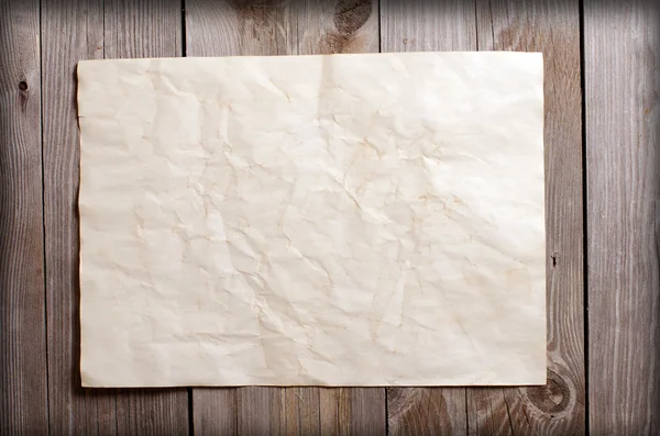 Papel viejo sobre una superficie de madera — Foto de Stock