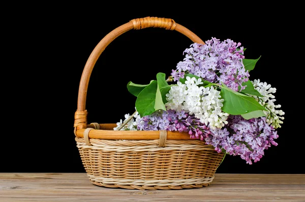 Ramo de lila en una cesta de mimbre — Foto de Stock