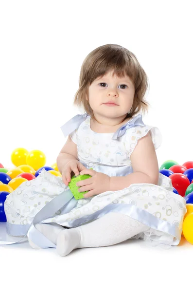 Маленькая девочка играет в разноцветные мячи — стоковое фото