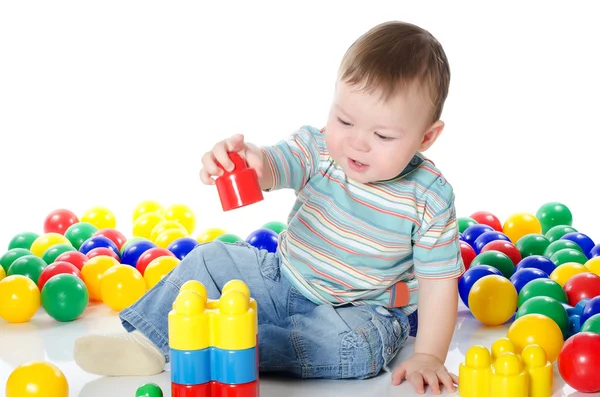 Мальчик играет в разноцветные игрушки — стоковое фото