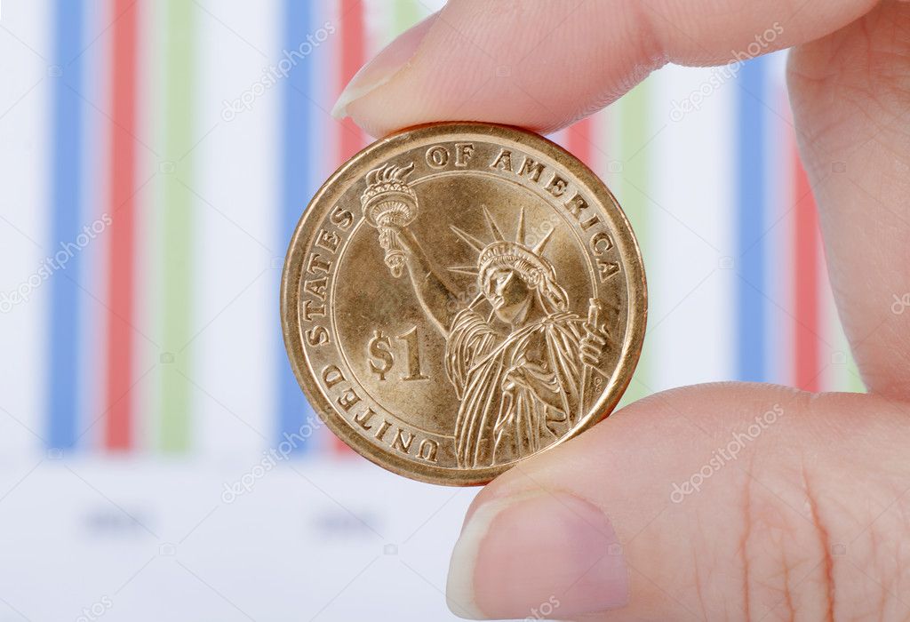 Coins in a hand against business of diagrammes
