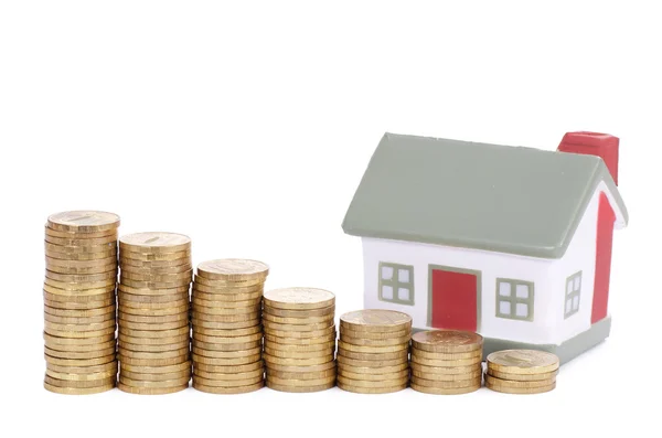Toy small house and coins in the form of the diagram. concept — Stock Photo, Image