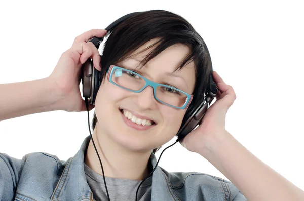 Menina ouve música através de fones de ouvido — Fotografia de Stock