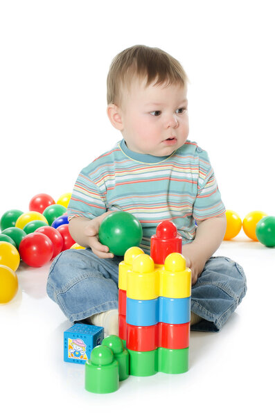 The little boy plays multi-coloured toys